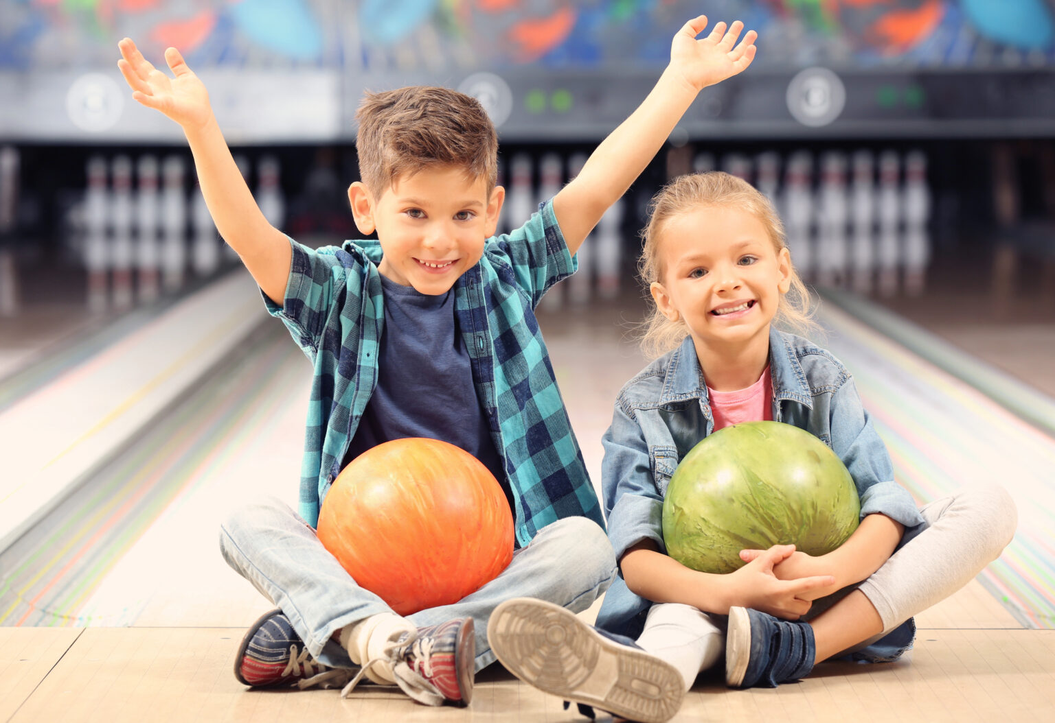 Kinder mit Bowlingkugeln auf der Bahn